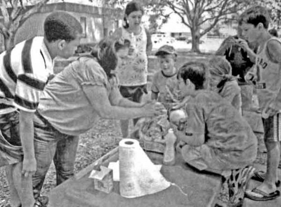 Making science fun for campers. Julie Doucet prepares a volcano for Louisiana State University Eunice BENGAL campers in the Science is Fun class. The volcano, made from modeling clay fashioned by the campers, shows the chemical interaction between ingredients which produces a bubbling eruption. Campers from left are Jaedon Dupre, Kennedy Fruge, Wesley Lejeune, Payton Naquin, Ali Lantz and Avery Ortego.