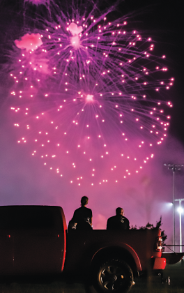A pickup truck provides a great vantage point for these two people watching the Eunice Fourth of July fireworks display at the Eunice Recreation Complex on Monday. (Photo by Dwight Jodon)