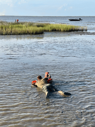Senior Agent Joshua Segrest makes his way through the mud to get to the stranded boaters. (Louisiana Department of Wildlife and Fisheries photo)