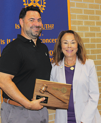 Past Rotary President Jacob Bergeron passes the gavel to newly-elected Rotary President Nancee Sorenson.