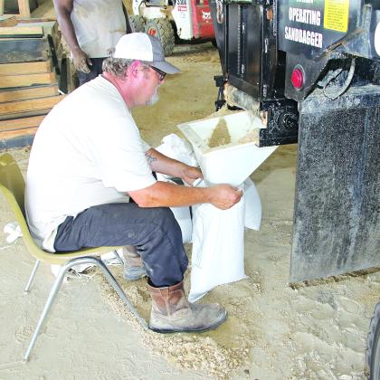 St. Landry Parish Government worker David Courville fills sandbags at the Yambilee Building in Opelousas on Tuesday afternoon. (Photo by Harlan Kirgan.