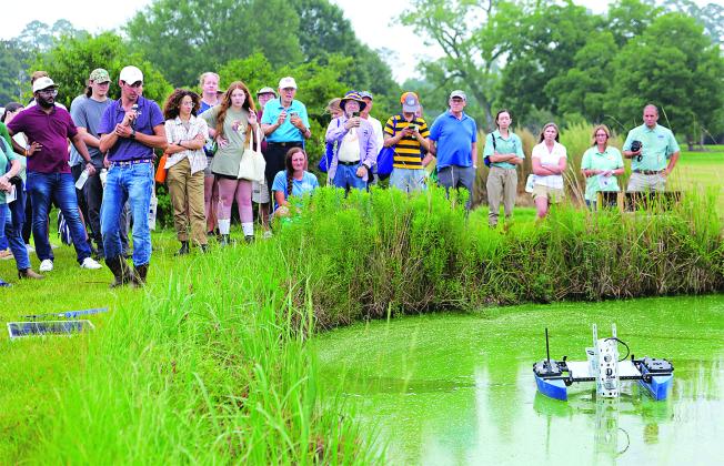 M.P. Hayes, an LSU AgCenter water quality expert, demonstrates a small, remote-controlled boat that can gather data to help monitor pond conditions. (Photo by Olivia McClure/LSU AgCenter)