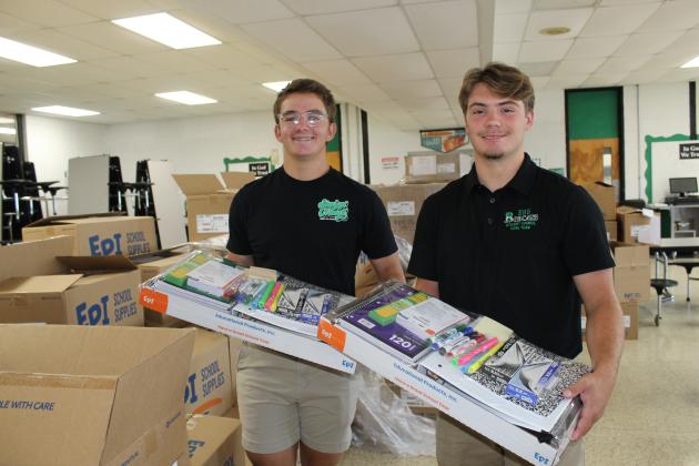 Distributing free school supplies to students during Eunice High registration Tuesday morning were Aiden LeJeune, left, and Andrew Fontenot, both seniors.