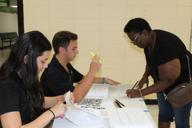 Gloria Janice fills out information for a EHS handbook for her son Elijah Ceasar, a senior. Assisting her from left are Kaylee Fontenot and Parker Pedigo, both seniors at Eunice High.