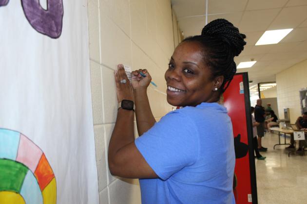 Sometimes it just takes a wall to fill out a student check out record card. Above is Kimberly Kennedy. Her daughter is Madison Andry, a senior at Eunice High.