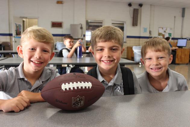 St. Edmund students waited inside the school’s cafeteria before the first bell of school sounded. From left are Jax Lavergne, Kolt McGee and Lane Miller, all second graders.