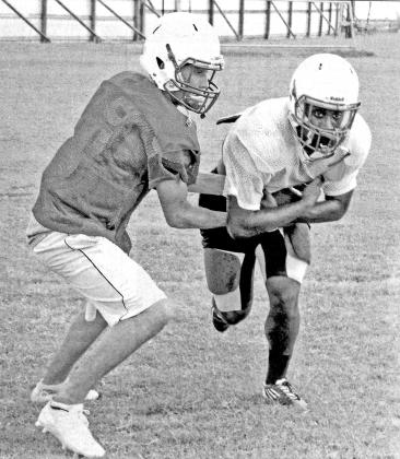 Eunice High quarterback Alex Richard hands the ball to a teammate during a drill. The Bobcats will scrimmage at Kaplan at 5:30 p.m. Friday.