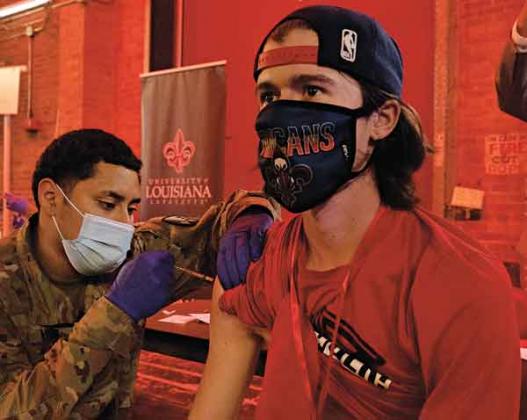 A member of the Louisiana National Guard administers a COVID-19 vaccine to a UL Lafayette student at the campus’ testing and vaccination center last week in Burke-Hawthorne Hall. (Photo by  Doug Dugas / University of Louisiana at Lafayette)