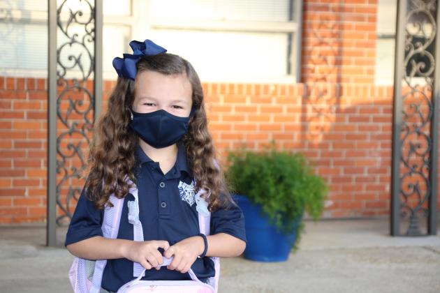 Ayda Fuselier, a kindergarten student at St. Edmund Elementary, arrives on campus Monday morning for her first day of school. All students reported Monday for a full day of classes.