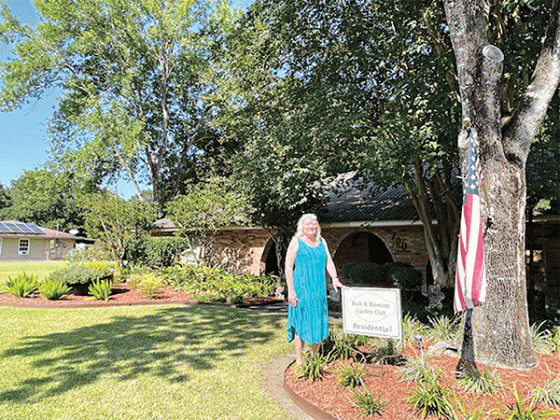 The Ken and Lisa Richard home on Hill St. was awarded the Residential Yard of the Month by the Bulb and Blossom Club of Eunice. Featured predominantly in the yard is a sugar kettle which is planted with blue daze and white plumbago. Other plantings include towering crepe myrtle trees and mature ligustrum and camellia shrubs. Lariope, variegated ginger, agapanthus, foxtail ferns and knock out roses add to the lush under plantings.  Pictured is Lisa Richard.