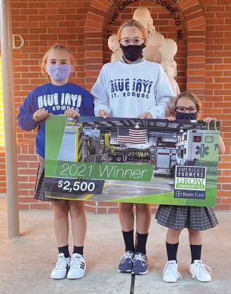 Raymond and Tammy Fruge’s granddaughters at St. Edmund proudly display a $2,500 from Bayer Fund America’s Farmers Grow Communities donation to their school. From left, are Aisley Fruge, Reese Fruge and Clara Fruge. (Submitted photo)