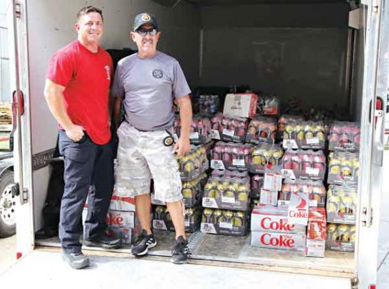 Ryan Daville, left, and Danny Soileau are with a load of drinks on Tuesday afternoon at the Central Fire Station in Eunice. Soileau, with the Eunice City Marshal’s Office, was going to drive the trailer load of supplies to the hurricane-damaged area. Daville is a Eunice firefighter. (Photo by Harlan Kirgan)