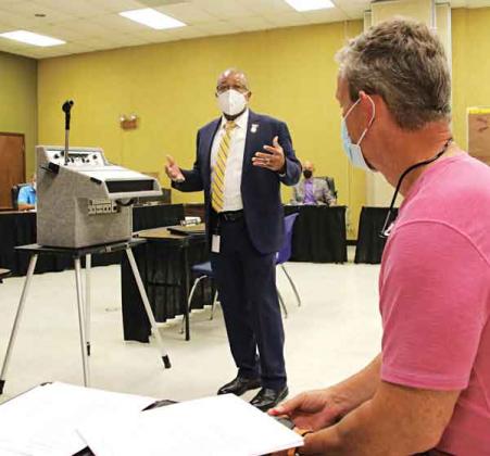 Patrick Jenkins, standing, St. Landry Parish school superintendent, addresses a committee of the whole meeting Thursday on capital improvement plans. At right is Lyn Henley, a consultant from Volkert Inc. (Photo by Harlan Kirgan)