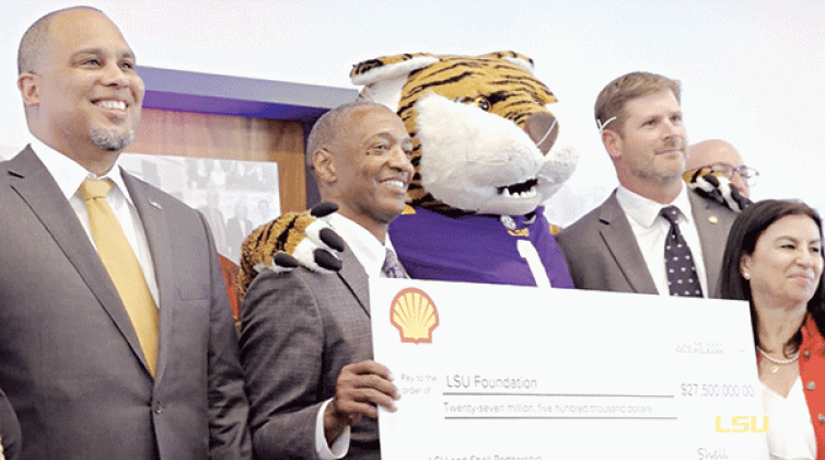 Shell, one of the biggest oil companies in the world, gave $27.5 million to LSU in 2022 to fund the university’s Institute for Innovation in Energy. LSU President William F. Tate IV, second from left, poses with LSU mascot Mike the Tiger. A new paper calls for additional research into the influence of the fossil fuel industry on academia. (LSU photo)