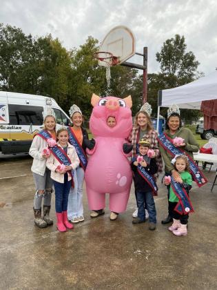 Swine Festival royalty enjoying last year’s event is seen above. From left, are,  Ava Manuel, Mallory Ortego, Bailey Stelly, Champion Hog Caller Jackie Ravey in the pig costume, Abigail Fruge, Carson Johnson, Vanessa Lastrapes, and Skyla McElfresh.  (Submitted photo)
