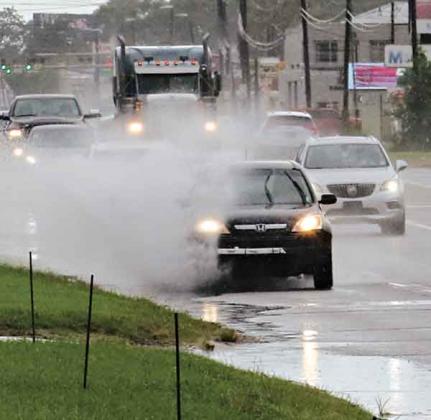 U.S. 190 was a splashy ride on Tuesday and Wednesday as the area received showers. At least 3 inches of rain fell Tuesday. The rainy weather is forecast to continue today. (Photo by Harlan Kirgan)