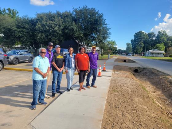 Satellite Social members, Mayor Scott Fontenot, Council woman Germaine Simpson on newly constructed sidewalk in front of Good Hope Apartments