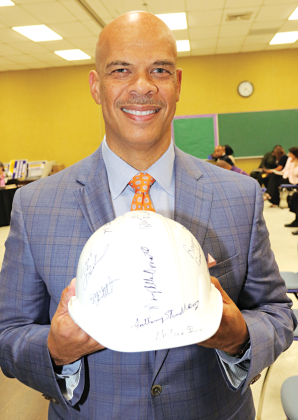 Preston Castille, Helix Community Schools president, holds a hard hat signed by St. Landry Parish School Board members Thursday. The School Board approved a charter school application by Helix Community Schools. Two schools are planned for Opelousas. (Photo by Harlan Kirgan)