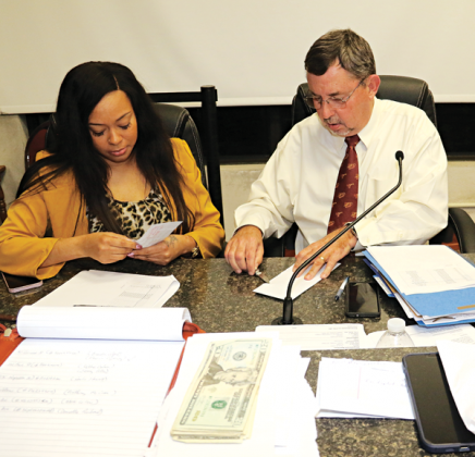 St. Landry Parish President Jessie Bellard, right, and Karia Rami, executive assistant and permit officer, open bids at the Jan. 5 Parish Council meeting in Opelousas. Also present at the bid opening was Richard Lewis, code enforcement director. (Photo by Harlan Kirgan)