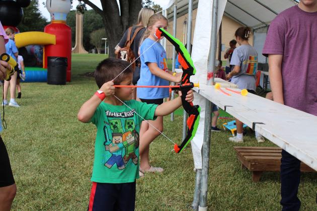 Colt Maxfield, 5, of Mamou, tries a bow and arrow kids game at the St. Thomas More Church’s annual bazaar Saturday.
