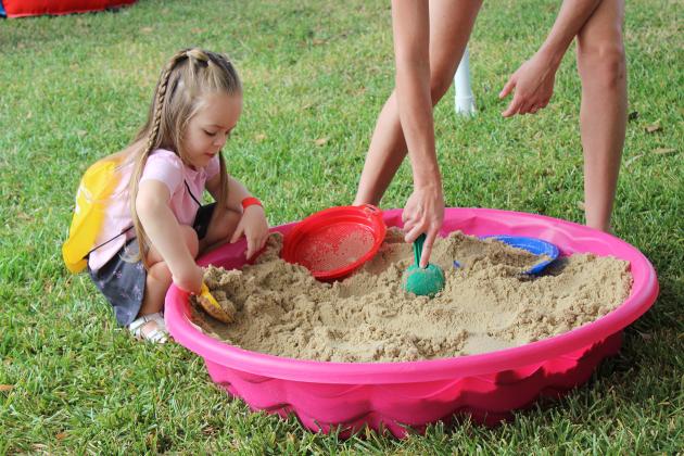 Ivy Daniels, 3, of Lake Charles, enjoys her play time with a sand box at the St. Thomas More Church Bazaar.