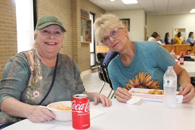 Jennifer Himel, left, and Jackie Naquin chose shrimp dishes for their lunch at the bazaar at St. Thomas More Catholic Church.