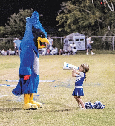 Karter Lejeune, 4,  uses a megaphone to chat with St. Edmund mascot Bluedreaux (Melody Fuselier) during last week’s game against Westminster Christian Academy. Karter’s parents are Dana and Jared Lejeune. Her brother, Jay, and sister, Caroline, are multi-sport athletes at St. Edmund. (Photo by Dwight Jodon)