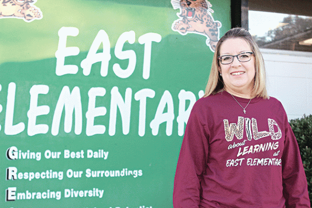 East Elementary Principal Gina LaGrange is with a sign outside the school on Friday morning. East Elementary earned its third A in the state’s school performance scores. (Photo by Myra Miller)
