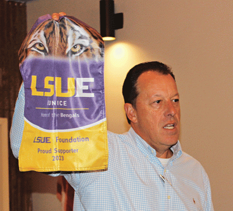 Kip Bertrand holds up a new 2023 LSUE Foundation flag that businesses can purchase for $200 each. Bertrand’s goal is to sell 200 to beat last year’s sales of 100. For more information, or to purchase a flag, call Ray Zorn at LSUE at 337-550-1281. (Photo by Myra Miller)