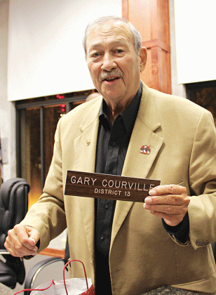 Gary Courville holds his nameplate at the St. Landry Parish Council meeting room during his final meeting. Courville, who held office for 23 years, died on Nov. 30. (File photo)