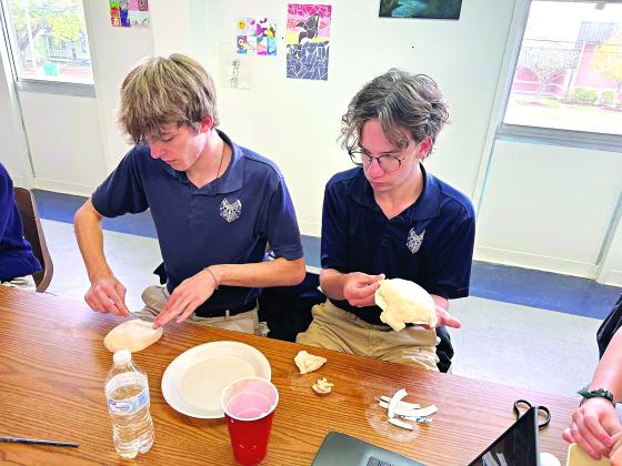 Brennon Manuel, left, and Simon Richard, both seniors, are creating their own versions of pottery inspired by Ancient Greek art. They are in Allison Reed’s Fine Arts Survey class at St. Edmund High.