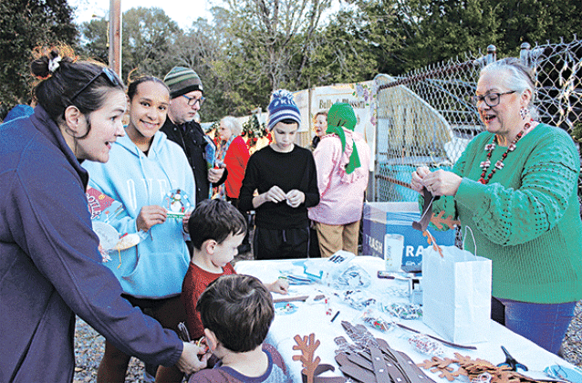 Angela Huckaby with CDA Court 208 demonstrates how to craft reindeer antlers at the Eunice Community Garden Christmas Festival Thursday. From left are Gabriel Daire, Branson Daire, Gina Daire, Jayla Mickens, Michael Laird and Jax Laird. Huckaby also had crafts of Christmas ornaments.Turn to Page 10 for more photos from the festival. (Photo by Myra Miller)