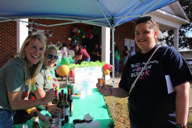 Erika Fontenot accepts a sample of wine from Courtney Bourgeois