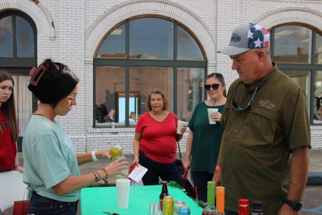 Jennifer Miller hands an Abita beer to Randy Toepfer