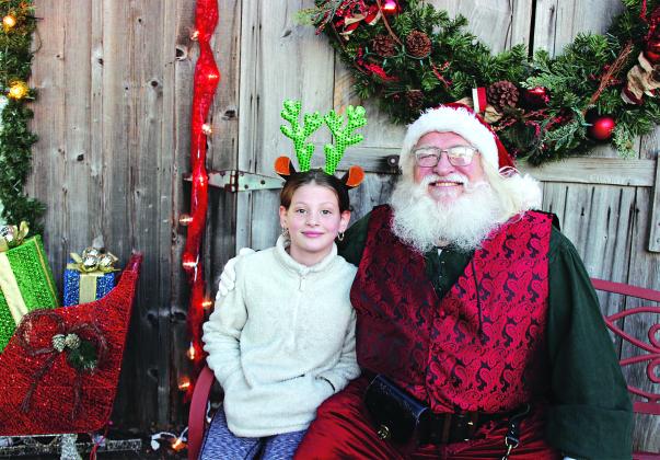 Adalyn Doucet made her Christmas wishes known to Santa at the 2023 Eunice Community Garden Christmas Festival. The festival returns from 5 to 7 p.m. today. (Photo by Myra Miller)