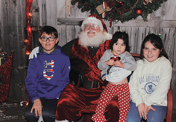 Santa paid a special visit to the Christmas Festival at the Eunice Community Garden Thursday evening. From left, are Landon DeVillier, 12, Santa, Lillie DeVillier, 3, and Lexie DeVillier, 8.