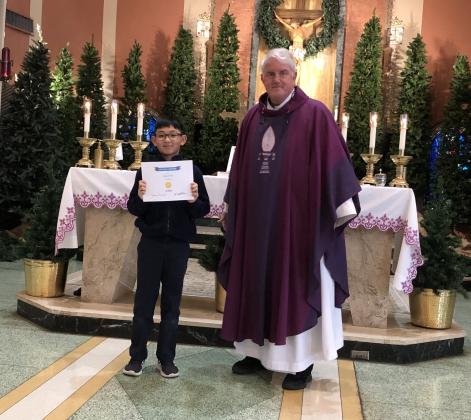 Joshua Yun, a fifth grader at St. Edmund Elementary, completed the entire fifth grade portion of the Aleks Math program. He is with the Rev. Hampton Davis.