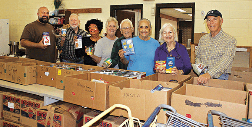 The Eunice Food Bank annual Food Drive was held Tuesday. Many volunteers were on hand ‘giving a hand.’ The early morning volunteers at the food bank included, the Rev. Heath McWilliams, left, David Guillory, Mary Ann Guillory, director; Jean Vige, Harry Reed, Tina Thomas, Darilyn Ardoin and Ron Driggs. (Photos by Myra Miller)