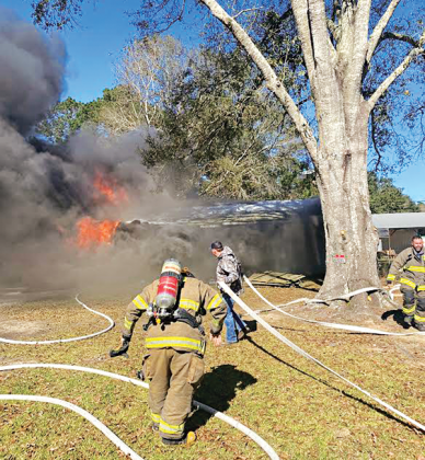 Acadia Parish Fire District 4 firefighters race to a house fire at 227 McManus Road on Sunday. The house of La. 13 south of Eunice was destroyed. Turn to Page 2 for the story and an additional photo. (Photo courtesy of Fire Chief Harral Johnson)