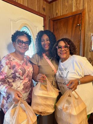 Sandra H. Wilkins, left, Shelsy Williams, branch president, and Philomena Bernard were on their way to deliver Thanksgiving luncheons to the elderly.