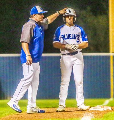 St. Edmund head coach Barry Manuel congratulates Clay Aguillard when he reached third base.