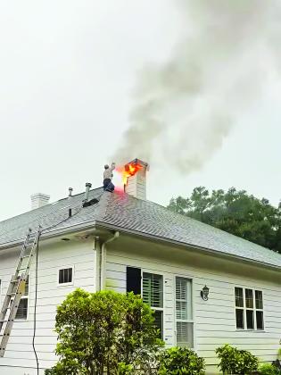 SLEMCO lineman Matt Reed used a hose to douse a house fire near Church Point on July 17. (Submitted photos)