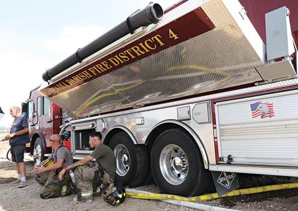 Firefighters take a break from the sun in the shade of an Acadia Parish Fire District 4 truck. From left, are Harral “New York” Johnson, Acadia Parish Fire District 4 chief; Chris Pierrotti, Eunice volunteer firefighter; and Dylan Fontenot, St. Landry Parish Fire District 6 volunteer.