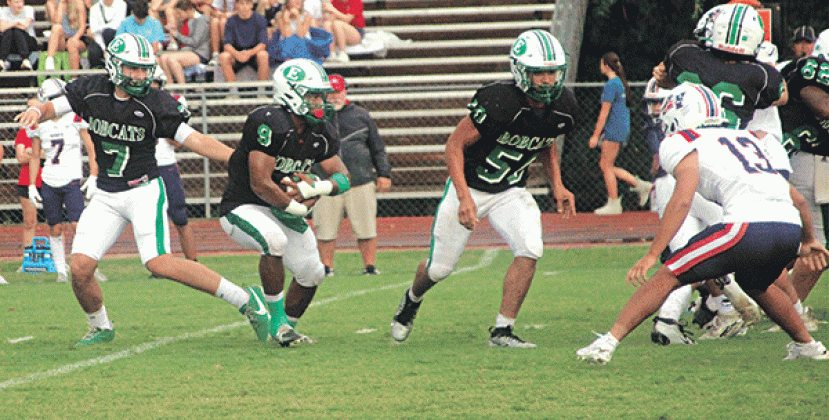 The Eunice High Bobcats started off slow, but made adjustments and defeated the North Vermilion Patriots 14-6 in a jamboree contest on Aug. 29 in Rayne. From left, Montana Brown, quarterback,completes a handoff to running back Bryan Allen as guard Christopher Malbrough leads for a block. (Photo by Rhett Manuel)