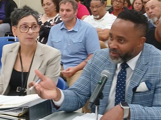 Board attorney Courtney Joiner, Superintendent's secretary Valencia Thierry looks at the presentation