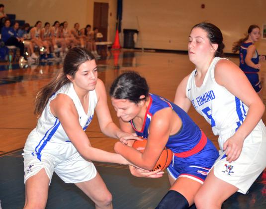 St. Edmund’s Jillian DeVillier and Alice Brown battle South Cameron’s  Reagan Veronie for a jump ball. (Photo by Tom Dodge)