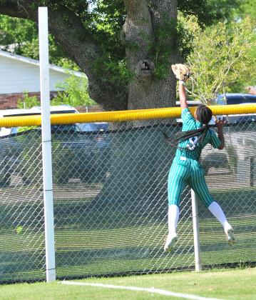 Eunice High right fielder Harmony Jason leaps as a North DeSoto home run clears the fence.