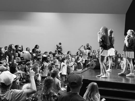 Kids singing facing the stage