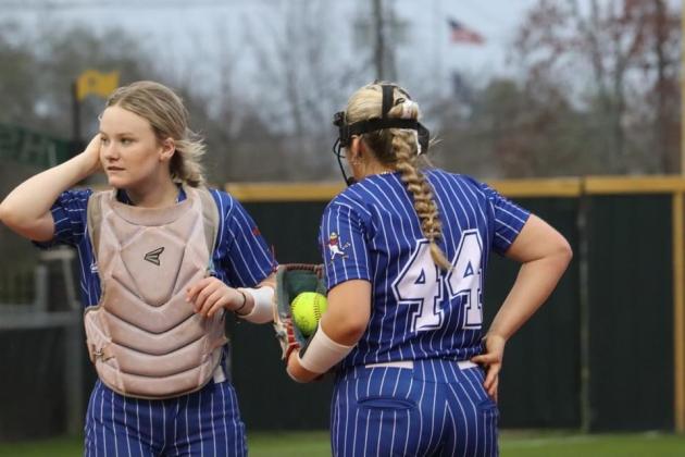 St. Edmund catcher Jenna Smith meets with Lady Jay pitcher Nicole Evans during a timeout against Menard.