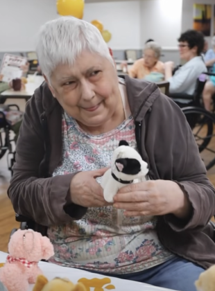 Smiling woman holding stuffed puppy